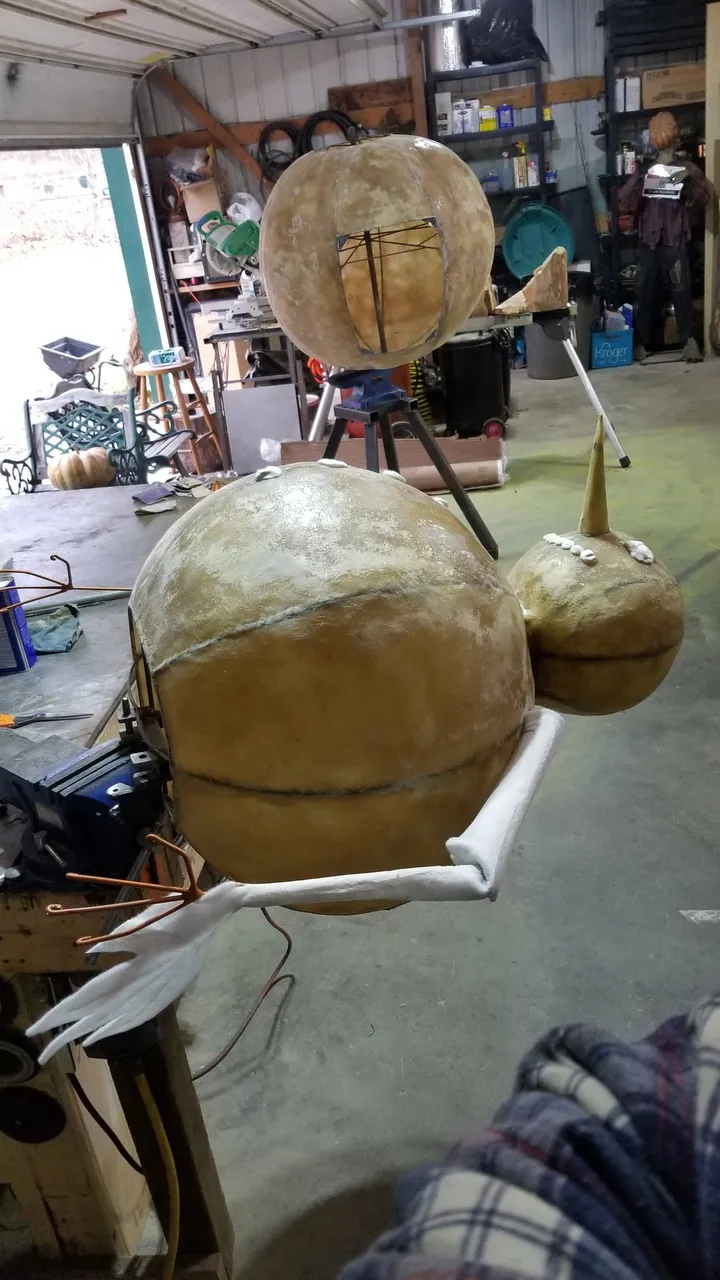 Assembled tan fiberglass Frosty the Snowflake animatronic standing in the studio before paint