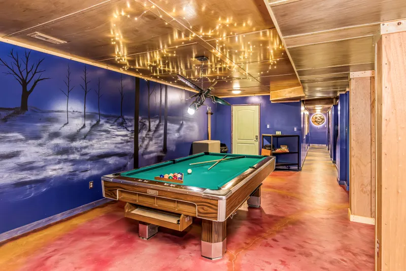 Hand-painted mural paired with a custom metal lighting sculpture, installed at Raven's Retreat