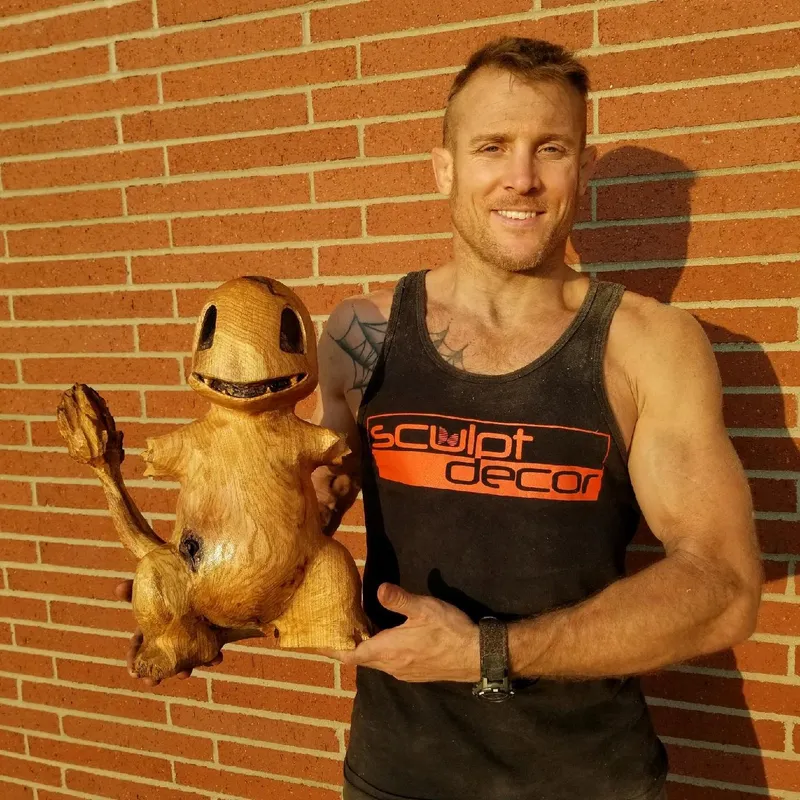 Dustin Weatherby holding a carved wood Charmander